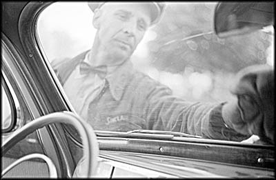 Attendant wiping a windshield at a gas station in Cairo, Illinois. 